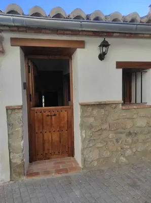 an entrance to a house with a wooden door at La Vía Verde in Jérica