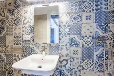a bathroom with a sink and blue and white tiles at ApartUP Central Market I in Valencia