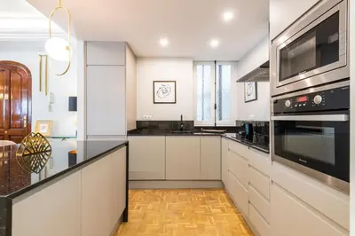 a kitchen with white cabinets and black appliances at MD Pasaje Ruzafa in Valencia