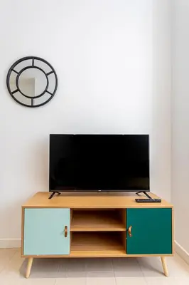 a tv on top of a wooden entertainment center at R&C APARTMENTS CLOSE to CENTER in Valencia