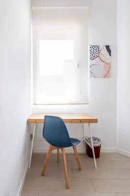 a desk with a blue chair next to a window at R&C APARTMENTS CLOSE to CENTER in Valencia