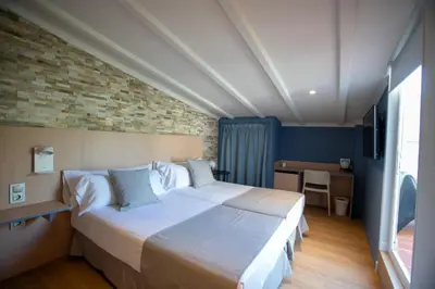 a bedroom with a large bed and a desk at Olympia Consul del Mar in Valencia