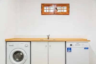 a kitchen with a washing machine and a sink at La Colina in Puebla de Vallbona