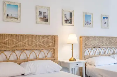 a bedroom with two beds and a table with a lamp at La Colina in Puebla de Vallbona