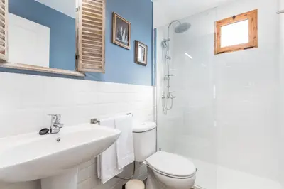 a white bathroom with a sink and a toilet at La Colina in Puebla de Vallbona