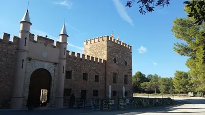 a large brick building with a gate and turrets at Castillo con piscina en plena Sierra Calderona in Segorbe