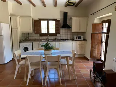 a kitchen with a table and chairs in it at Castillo con piscina en plena Sierra Calderona in Segorbe