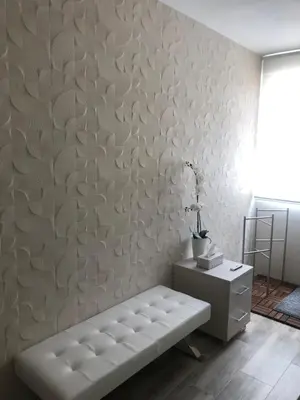 a living room with a white wall with a bench at Betero Beach & City in Valencia