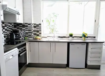 a kitchen with white cabinets and a sink at Islas Canarias Apartment in Valencia