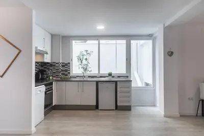 a kitchen with white cabinets and a large window at Islas Canarias Apartment in Valencia