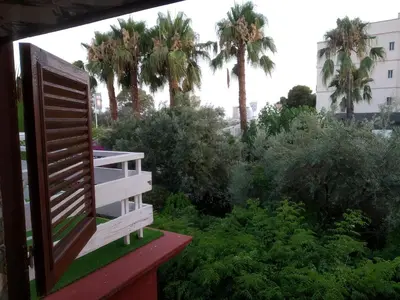 a balcony view of a garden with palm trees at Apartamento con terraza y vistas al mar in Burriana