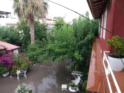 a balcony with a rain soaked yard with plants at Apartamento con terraza y vistas al mar in Burriana