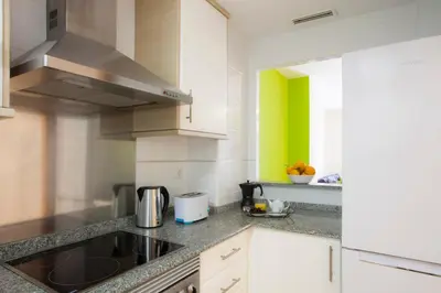 a kitchen with a sink and a green wall at SingularStays Moncofar Beach in Moncófar
