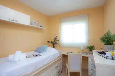 a bedroom with a white bed and a desk at SingularStays Moncofar Beach in Moncófar