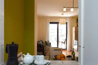 a living room with green walls and a table with dishes at SingularStays Moncofar Beach in Moncófar