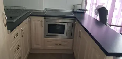 a kitchen with a purple counter top and a microwave at Faro de Cullera I in Faro de Cullera