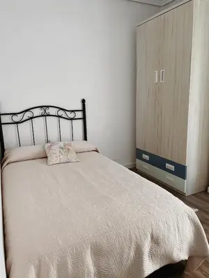 a bedroom with a bed and a wooden cabinet at Slow Room Valencia in Valencia