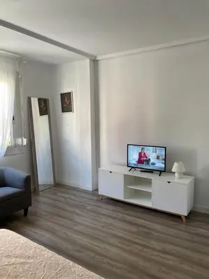 a living room with a flat screen tv on a cabinet at Slow Room Valencia in Valencia