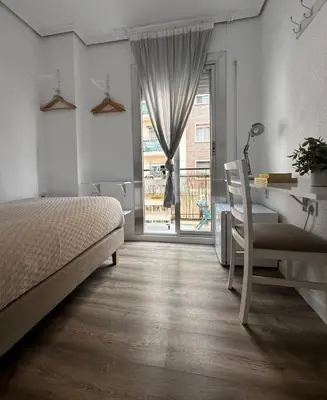 a bedroom with a bed and a desk and a window at Slow Room Valencia in Valencia