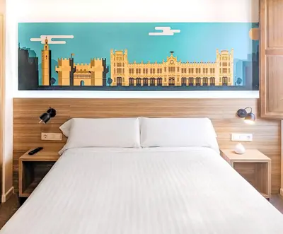 a bedroom with a bed with a painting of a building at Hotel Original Domino House in Valencia