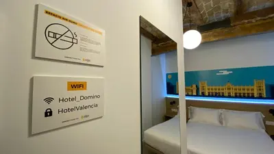 a room with a bed and a sign on a wall at Hotel Original Domino House in Valencia