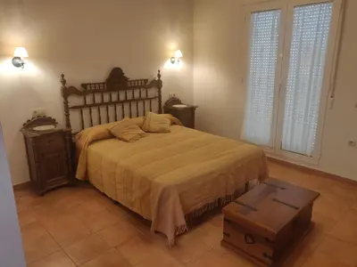 a bedroom with a large bed with a wooden headboard at Casa Josefina in Yátova