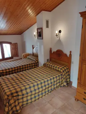 a bedroom with two beds and a wooden ceiling at Casa Josefina in Yátova