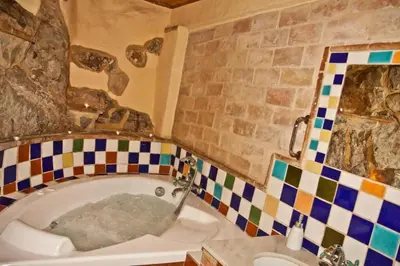 a bathroom with a tub with a tiled wall at La Casa Mora in Jérica