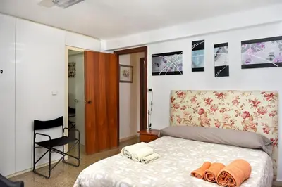 a bedroom with a bed with two flip flops on it at Calicanto House & Pool in Torrent