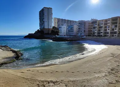 a beach with some buildings and the ocean at Seabreeze Lighthouse Apartment in Faro de Cullera