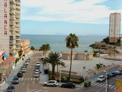 a city street with cars parked on the beach at Seabreeze Lighthouse Apartment in Faro de Cullera