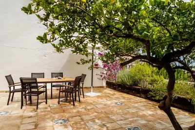 a patio with a table and chairs and a tree at Casa rural la ermita de Anna in Anna