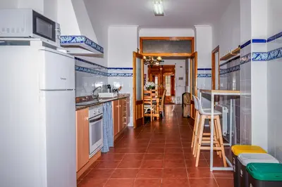a kitchen with white appliances and brown tile floors at Casa rural la ermita de Anna in Anna