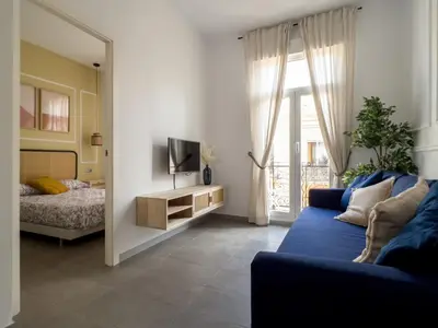 a living room with a blue couch and a television at Maritime Apartamentos Cabañal in Valencia