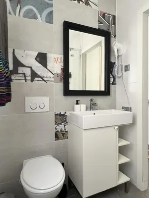 a bathroom with a toilet and a sink and a mirror at Maritime Apartamentos Cabañal in Valencia