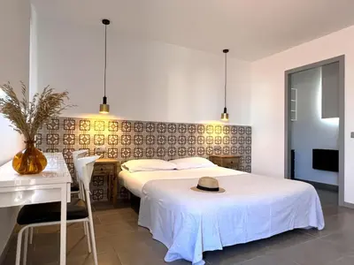 a bedroom with a bed and a table with a hat on it at Maritime Apartamentos Cabañal in Valencia
