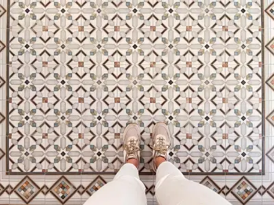 a person in shoes standing in front of a tile wall at Maritime Apartamentos Cabañal in Valencia