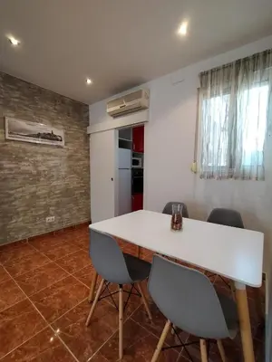 a dining room with a white table and chairs at Cabañal Port Marina in Valencia