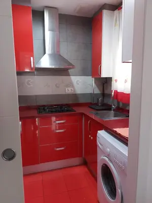 a kitchen with red cabinets and a washing machine at Cabañal Port Marina in Valencia