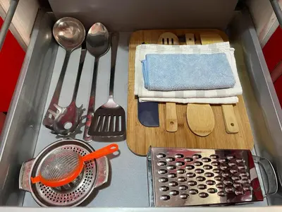 a kitchen counter with utensils in a sink at Cabañal Port Marina in Valencia