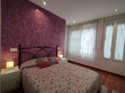 a bedroom with a bed and a purple wall at Cabañal Port Marina in Valencia