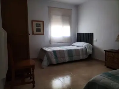 a bedroom with a bed and a window and a chair at Ca Michico in Tous