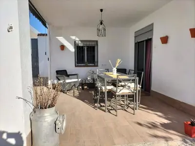 a dining room and living room with a table and chairs at Ca Michico in Tous