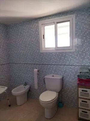 a bathroom with a toilet and a sink and a window at Ca Michico in Tous