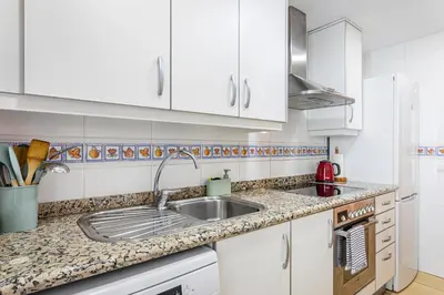a kitchen with white cabinets and a sink at Playa Valencia Residencial Sol y Mar Terraza con Vistas y Parking in Playa Pobla de Farnals