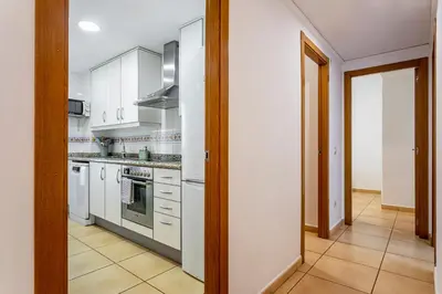 a kitchen with white appliances and a hallway at Playa Valencia Residencial Sol y Mar Terraza con Vistas y Parking in Playa Pobla de Farnals