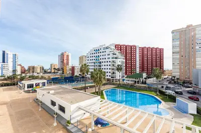 an apartment with a swimming pool in a city at Playa Valencia Residencial Sol y Mar Terraza con Vistas y Parking in Playa Pobla de Farnals