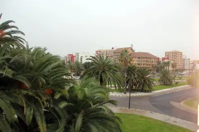 a view of a street with palm trees and buildings at Holiday Apartments Malvarrosa Beach in Valencia
