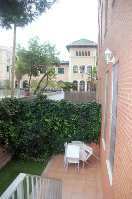 a patio with a table and chairs next to a building at Holiday Apartments Malvarrosa Beach in Valencia