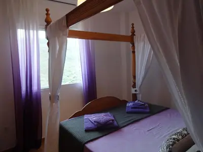 a bedroom with a canopy bed with a window at LAS PALOMAS, appartement 3 chambres avec piscine in Turís